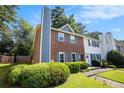 Inviting two-story townhome showcasing a brick facade and a professionally landscaped yard at 1919 Cheatham Woods Sw Dr, Marietta, GA 30008