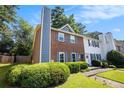 Beautiful townhome featuring a brick facade, gray shutters, and a well-maintained front lawn at 1919 Cheatham Woods Sw Dr, Marietta, GA 30008