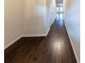 Long hallway with dark wood floors and white trim, leading to other rooms at 3375 Highbury Way, Lithonia, GA 30038