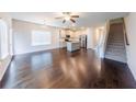 Open-concept living space with hardwood floors, flowing into the kitchen with island and stairs at 3375 Highbury Way, Lithonia, GA 30038