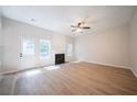 Bright living room with a fireplace, ceiling fan, new floors, and a door leading to the backyard at 4815 Price St, Forest Park, GA 30297