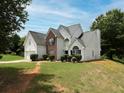 A charming home boasts a lush lawn and a classic architectural design that is both inviting and stylish at 148 Barrington Pkwy, Stockbridge, GA 30281