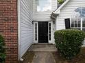 A black front door is flanked by sidelights and manicured bushes, creating a welcoming entry at 148 Barrington Pkwy, Stockbridge, GA 30281