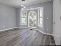 Bright bedroom featuring large windows, hardwood floors, neutral paint, and unique lighting at 2773 Hawk Trace Ne Ct, Marietta, GA 30066