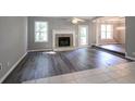 Open living room with a fireplace, gray walls, and wood flooring, leading to the dining room at 2773 Hawk Trace Ne Ct, Marietta, GA 30066