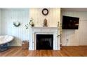 Cozy living room featuring a fireplace with white mantel and hardwood floors, creating a warm and inviting space at 420 Ashbury Cir, Dallas, GA 30157