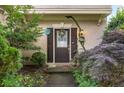 Welcoming front entrance with decorative wreath, blooming plants, and cozy lighting, showcasing home's curb appeal at 5035 Foxberry Ln, Roswell, GA 30075