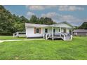 Side angle of home with covered porch, deck, stylish railings and a lush green lawn at 2122 Browntown Rd, Rockmart, GA 30153