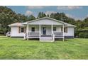 Charming home featuring a covered porch with stylish railings and lush green lawn at 2122 Browntown Rd, Rockmart, GA 30153