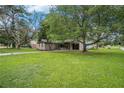 Expansive green lawn leads to a quaint brick home shaded by mature trees at 5400 Louis Xiv Ln, Atlanta, GA 30349