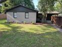 Charming single-story home with a well-maintained front yard, mature tree, and a covered carport at 5400 Louis Xiv Ln, Atlanta, GA 30349