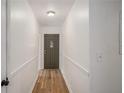Bright hallway featuring wood-look floors and a classic paneled front door at 5400 Louis Xiv Ln, Atlanta, GA 30349