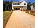 Two-story house with an attached garage and a long driveway leading to it surrounded by a landscape of trees at 7216 Eton Ln, Locust Grove, GA 30248