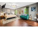 Bedroom with hardwood floors, gray walls, ceiling fan, and many artworks at 1491 Stonington Ct, Villa Rica, GA 30180