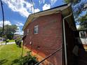 Exterior shot of the brick home showing the side and fenced yard, with mature landscaping at 2933 Arlington Rd, East Point, GA 30344