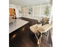 Bright living room with wainscoting, hardwood floors, stylish chairs, telescope, and large window at 3201 Palisades Se Ct, Marietta, GA 30067
