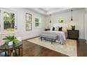 A serene bedroom with tray ceiling, hardwood floors, neutral tones and access to the backyard at 1272 Hardee Ne St, Atlanta, GA 30307