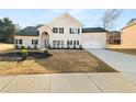 Beautiful two-story home with white brick exterior, dark shutters, arched entryway, and lush front yard at 4647 Lantern Ct, Stonecrest, GA 30038