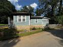 Exterior home featuring painted light blue wooden siding and a stone foundation at 6733 Old Covington Rd, Lithonia, GA 30058