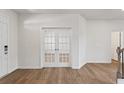 Bright foyer with wood floors, white walls, and glass French doors leading to another room at 237 Arwen Drive Lot 61, Mcdonough, GA 30252
