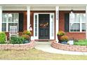 Welcoming front entrance with a charming floral wreath, lush plants and manicured landscaping at 3824 Smith Creek Ct, Buford, GA 30519