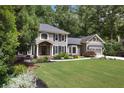 Lovely home featuring a manicured lawn, mature trees, and an attached two-car garage at 4249 Arbor Club Dr, Marietta, GA 30066