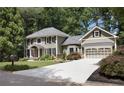 Well-maintained home features a spacious driveway leading to an attached garage, set amongst lush greenery at 4249 Arbor Club Dr, Marietta, GA 30066