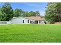 Expansive backyard with lush green grass, bordered by a white picket fence and mature trees for privacy at 145 Deep Step Rd, Covington, GA 30014