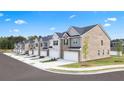 Row of newly built townhomes with brick and siding exteriors, manicured lawns, and private driveways at 245 Silver Moon Dr, Loganville, GA 30052