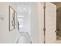 Bright hallway with wood-look floors, modern decor, and a view of the front door and an open bathroom at 541 Fundao Ln, Lawrenceville, GA 30046