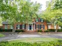 Two-story brick house with dark shutters and covered entryway surrounded by blooming trees at 6203 Crestview Drive Southeast Se Dr, Covington, GA 30014