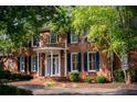 Close-up of a brick home with a covered entryway with white columns and dark shutters at 6203 Crestview Drive Southeast Se Dr, Covington, GA 30014