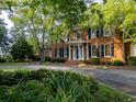 Brick home featuring a covered entryway, dark shutters, and mature landscaping at 6203 Crestview Drive Southeast Se Dr, Covington, GA 30014
