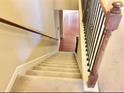 Carpeted staircase with natural wood banister leads to the lower level of the home at 1870 Garbrooke, Lawrenceville, GA 30046
