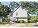 View of the side of a charming grey home with white trim and green landscaping at 1077 Mainstreet Valley Dr, Stone Mountain, GA 30088