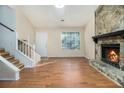 Inviting living room featuring a stone fireplace, wood floors, and natural light at 1077 Mainstreet Valley Dr, Stone Mountain, GA 30088