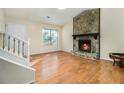 Bright living room showcasing wood floors, stone fireplace, and staircase at 1077 Mainstreet Valley Dr, Stone Mountain, GA 30088