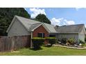 A quaint single-story home featuring a red brick accent wall, a screened porch, and a well-kept lawn at 20 Bacchus Dr, Lawrenceville, GA 30045