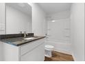 Bathroom featuring a granite countertop, white cabinets, and a shower-tub combo at 342 Orwell Drive Lot 95, Social Circle, GA 30025