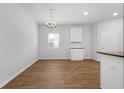 Bright dining area with wood floors, a modern chandelier, and white trim at 342 Orwell Drive Lot 95, Social Circle, GA 30025