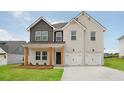 Charming home featuring a brick and siding exterior, two-car garage and a well-manicured lawn at 342 Orwell Drive Lot 95, Social Circle, GA 30025