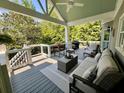 Comfortable covered deck with modern outdoor seating, ceiling fan, and views of the surrounding greenery at 5085 Johns Creek Ct, Johns Creek, GA 30022