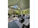 Stylish covered deck with outdoor seating, a ceiling fan, and views of the lush backyard landscape at 5085 Johns Creek Ct, Johns Creek, GA 30022