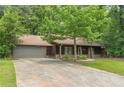 Charming exterior of a well-maintained home with a long driveway and a lush green lawn at 800 Greenwood Se Trl, Conyers, GA 30094