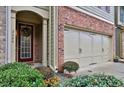 Close-up of townhome featuring brick accents, a garage, and a welcoming entrance at 2626 Sardis Chase Ct, Buford, GA 30519