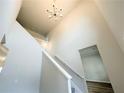 Modern staircase featuring soaring ceilings, a stylish chandelier, and wood flooring at 5032 Falcon Pt, Douglasville, GA 30135