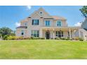 Charming two-story brick home with a manicured lawn and inviting front porch with hanging lanterns at 774 Phil Haven Ln, Kennesaw, GA 30152