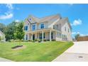 Charming two-story brick home with a manicured lawn and inviting front porch with hanging lanterns at 774 Phil Haven Ln, Kennesaw, GA 30152