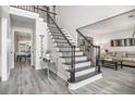 Elegant foyer featuring a staircase with black wrought iron spindles, gray floors, and a welcoming atmosphere at 3055 Dogwood Hollow Ln, Lawrenceville, GA 30043