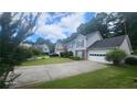 Suburban home with gray siding, green shutters, and a long driveway leading to a two-car garage at 3219 Roundfield Cir, Duluth, GA 30096
